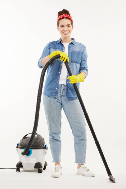 Pretty woman in work-wear uses a big wacuum cleaner. - Fotoğraf, Görsel