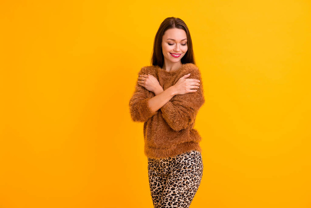 Photo of pretty lady hugging herself shoulders enjoy touch warm soft pullover youth trend look wear fluffy sweater leopard pants isolated yellow color background - Φωτογραφία, εικόνα