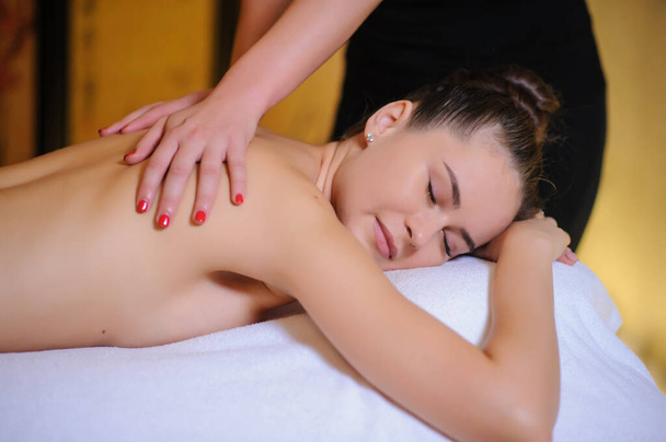 Massaggiatore che applica un massaggio di bellezza su un cliente femminile Vista laterale
  - Foto, immagini