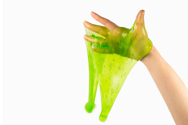 Zielony szlam zabawka w kobieta ręka odizolowany na biały. - Zdjęcie, obraz