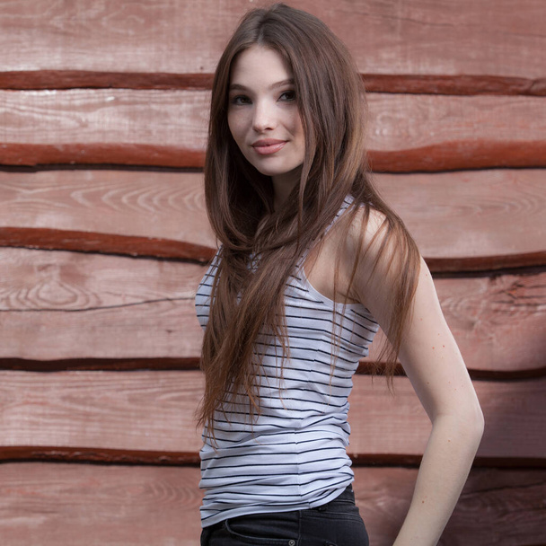 Portrait of beautiful young girl on wooden background. - Φωτογραφία, εικόνα