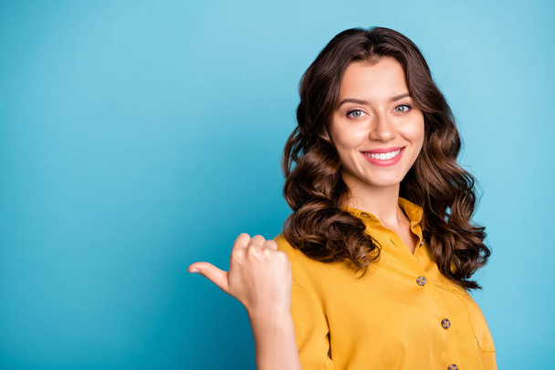 Fotografie okouzlující obchodní manažer dáma indikující palec prst prázdný prostor radí nový produkt nízká cena opotřebení žlutá košile izolované modré barvy pozadí - Fotografie, Obrázek