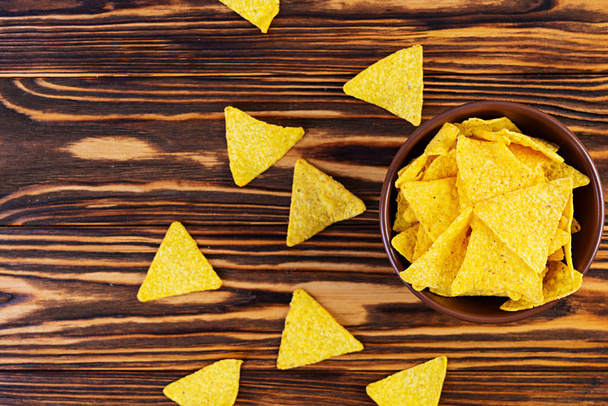 Mexican nachos with cheese. Corn chips isolated on wooden background - Fotografie, Obrázek