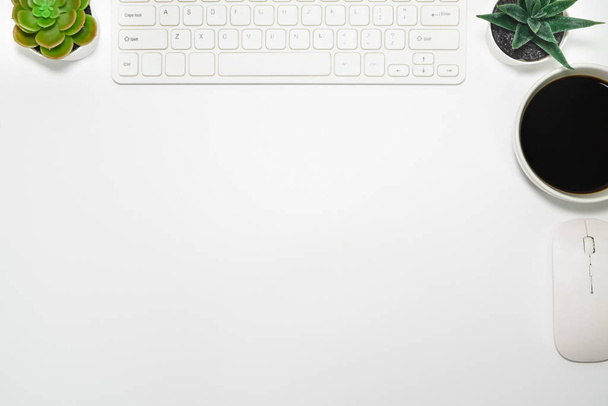 Плоский стол, белый стол. Вид сверху с клавиатуры, компьютерной мыши, растения горшок, суккуленты и чашку черного кофе. Вид сверху с пространством для копирования. Концепция бизнеса
. - Фото, изображение