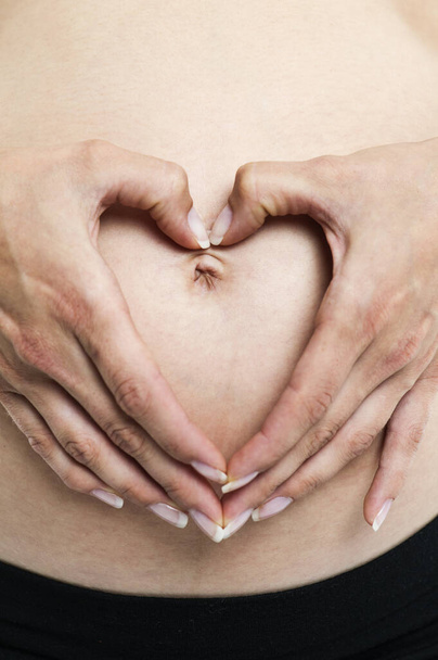 heart on the belly of a pregnant woman - Photo, image
