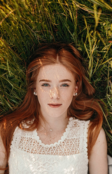 Ginger female lying on green grass - Foto, imagen