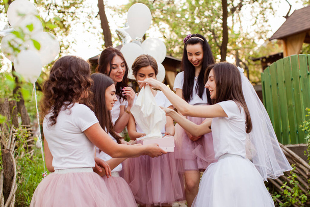 Jonge bruid opent de geschenkdoos op meisjes feest - Foto, afbeelding