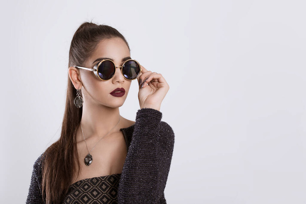 Closeup portrait confident successful beautiful attractive young woman fashion girl posing holding sunglasses hand on glasses isolated white grey background wall Positive human emotion face expression - Foto, Imagem