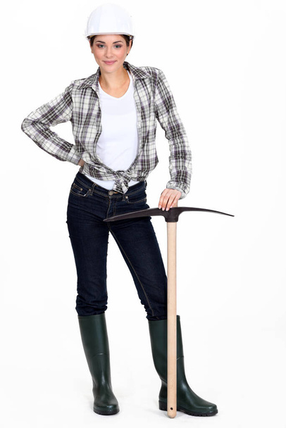Tradeswoman holding a pickaxe - Фото, изображение