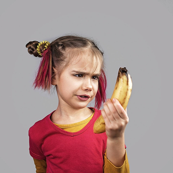 Freakish dziecko trzyma zniekształcony zły kolor owoców i warzyw,  - Zdjęcie, obraz