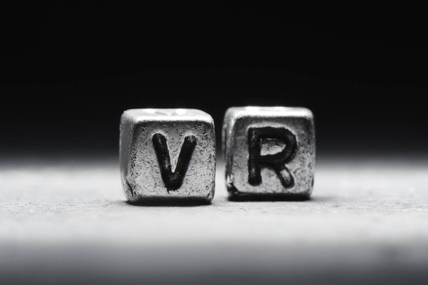 3d inscription virtual reality vr on metal cubes on a black gray background close-up isolated - Foto, imagen
