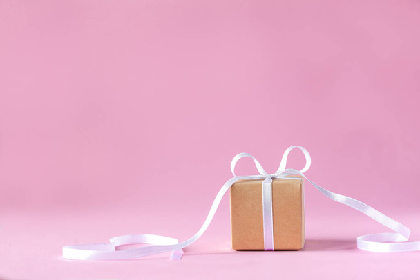 Gift or present box with white ribbon on pink background. Holiday greeting card. - Foto, Bild