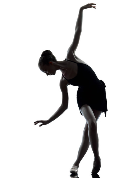 ένας καυκάσιος νεαρή γυναίκα Μπαλαρίνα χορευτής μπαλέτου τέντωμα ζέσταμα σε σιλουέτα studio σε λευκό φόντο - Φωτογραφία, εικόνα