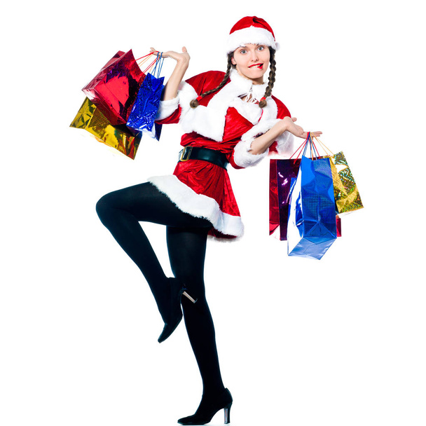 one woman dressed as santa claus carrying christmas bags  on studio isolated white background - Zdjęcie, obraz