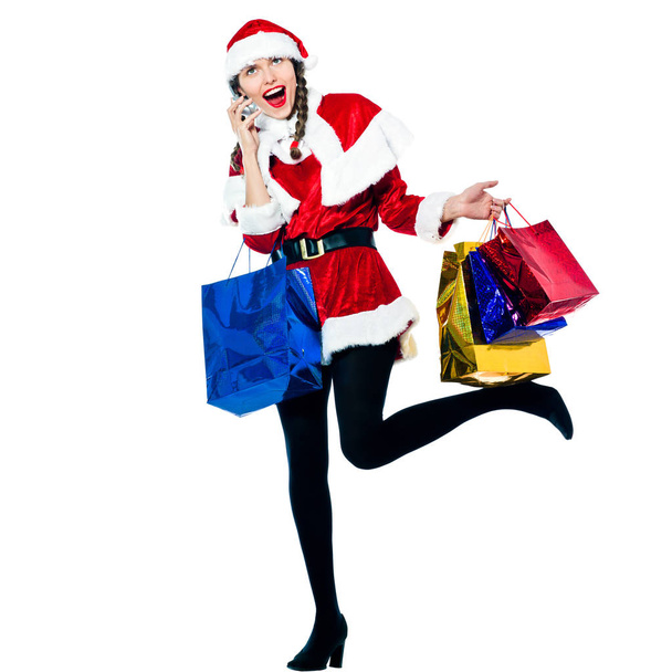 one happy woman dressed as santa claus carrying on the telephone christmas bags  on studio isolated white background - Foto, Bild