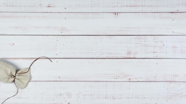 Stop motion animation des oeufs de caille rouler à partir d'un sac de toile de jute sur fond en bois, pose à plat. Concept Vacances de Pâques et printemps
  - Séquence, vidéo