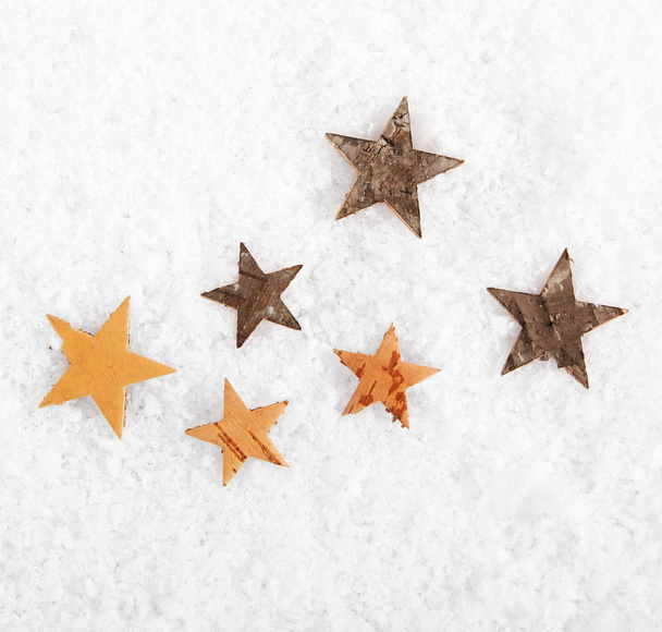 Arrière-plan saisonnier ou de Noël d'étoiles rustiques dispersées sur de la neige fraîche et blanche en hiver avec copyspace - Photo, image