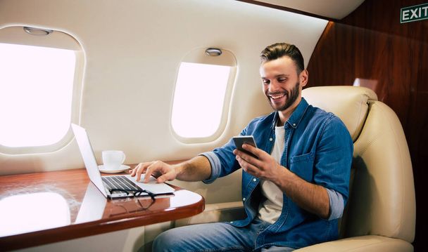 young businessman on the plane using smartphone  - Zdjęcie, obraz