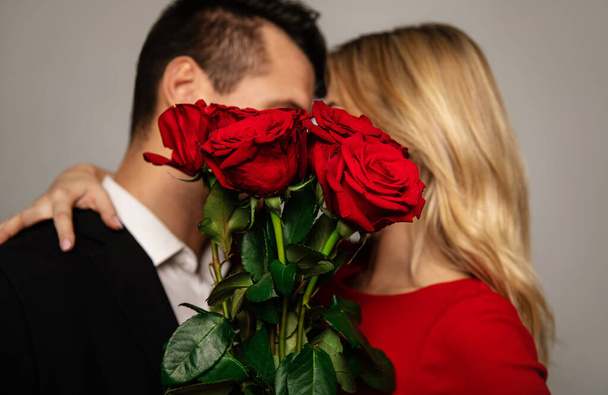 happy couple  with roses on studio background  - Valokuva, kuva