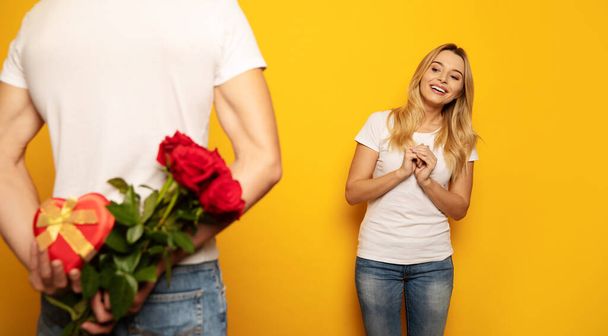 happy couple on studio background. man making surprise for woman   - Photo, Image