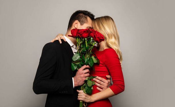 happy couple  with roses on studio background  - Zdjęcie, obraz
