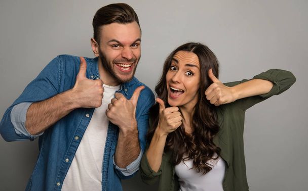 happy couple  with thumbs up on studio background  - Foto, immagini