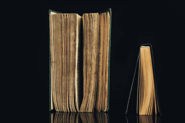 Όμορφα αρχαία βιβλία. Πλαίσιο φόντου για το σχεδιασμό. Το βιβλίο σε ένα μαύρο γυάλινο τραπέζι φόντο. - Φωτογραφία, εικόνα