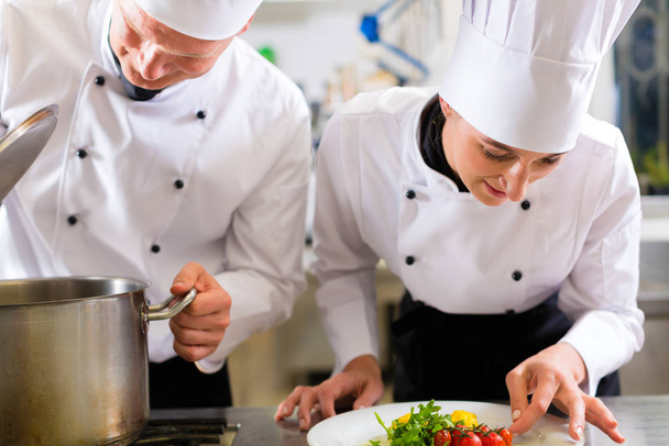 two chefs - man and woman - kitchen work in the hotel or restaurant and cook in a team - Φωτογραφία, εικόνα