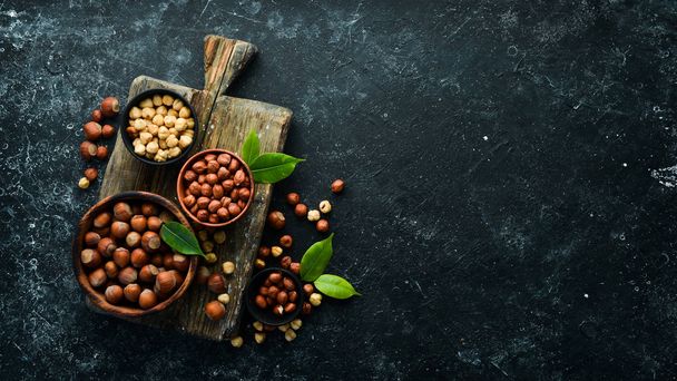 Hazelnuts in a bowl on a black stone background. Nut. free space for your text. Top view. - Fotó, kép