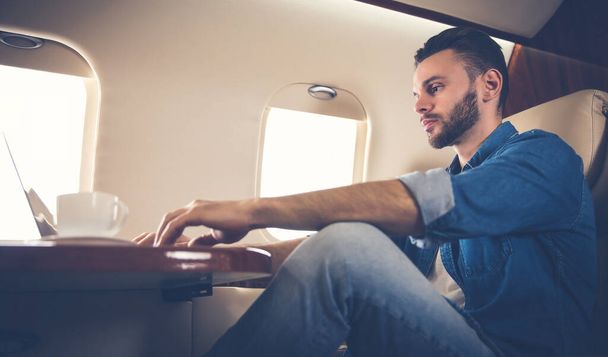joven empresario en el avión con portátil - Foto, Imagen