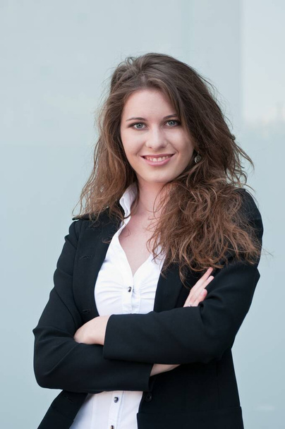 Young smiling business woman - portrait against plain glass background - Fotoğraf, Görsel