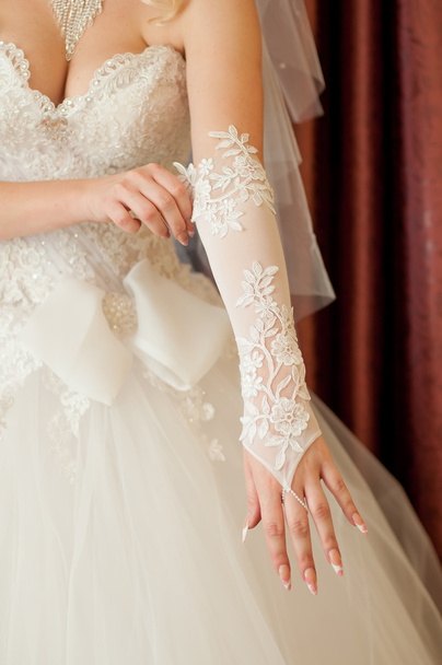 Bride dresses on their hands white gloves - Fotó, kép