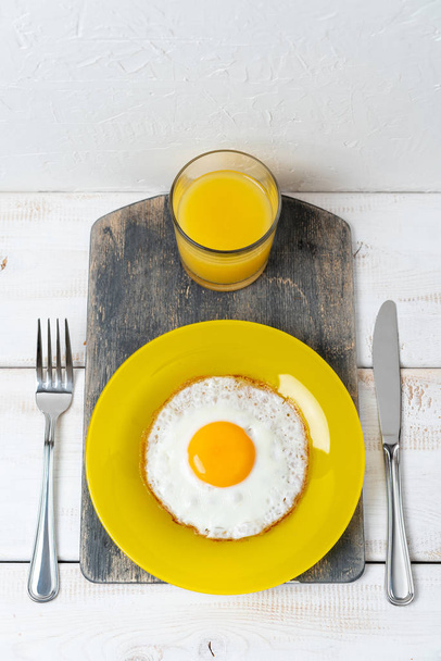 Sarı tabakta portakal suyu ile sahanda yumurta. Taze kahvaltı.. - Fotoğraf, Görsel