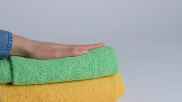 Lähikuva kädet laittamalla pino tuoreita kylpypyyhkeitä lakanaan. Huonepalvelu piika siivous hotellihuone makro
 - Materiaali, video