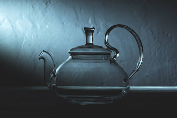 empty glass teapot on black background in spot light - Фото, изображение