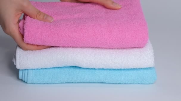 Primer plano de las manos poniendo pila de toallas de baño frescas en la sábana. Servicio de habitaciones limpieza limpieza habitación de hotel macro
 - Metraje, vídeo