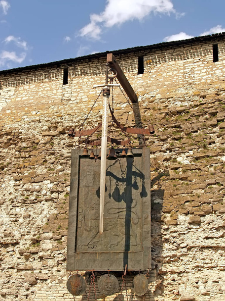 pskov, russland - 08. Mai 2010: Wappen und Schwert an der Wand des pskov krom (kremlin). russischer Text - wer mit einem Schwert kommt, wird durch das Schwert umkommen - Foto, Bild