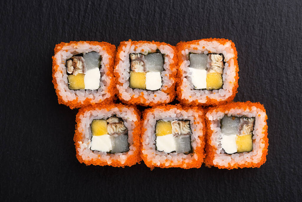 Szusi szett. maki, gunkan és sushi tekercsek kőlapon. Sushi meg egy kő lemez és sötét beton háttér. Sushi tekercs és evőpálcika. Friss japán konyha. Ázsiai kaja. Sushi kép az étlapra. közelről - Fotó, kép