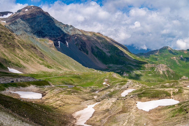 Green mountainsides with snow patches along Grossglockner High A - Photo, Image