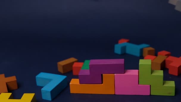 Közelkép Lassú mozgás. Kézfogás darab fa blokk puzzle. fakocka halmozás. Az összetett és intelligens logikai gondolkodás fogalma. fekete alapon - Felvétel, videó