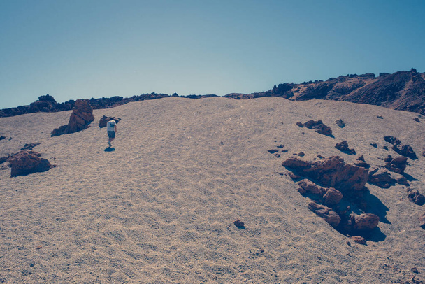 Ο άνθρωπος περπατά στα μοναχικά σεληνιακά τοπία  - Φωτογραφία, εικόνα