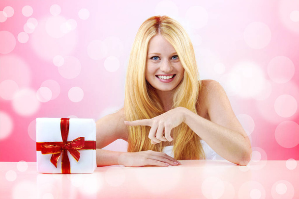 beautiful blonde woman holding a christmas gift is smiling - Photo, Image