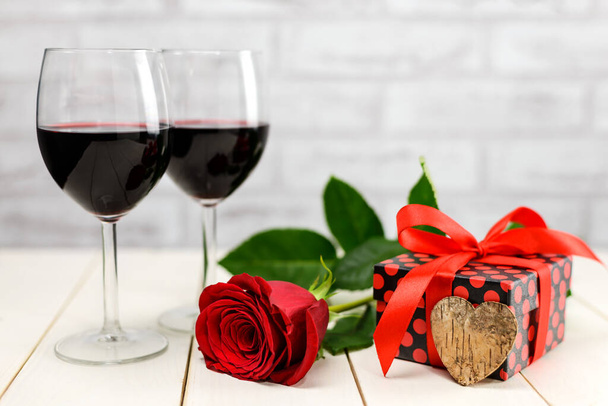 Bir kadeh şarap, güller ve hediye. - Fotoğraf, Görsel