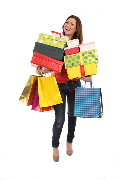 Happy woman carries shopping bags and birthday or christmas presents - Foto, Imagen