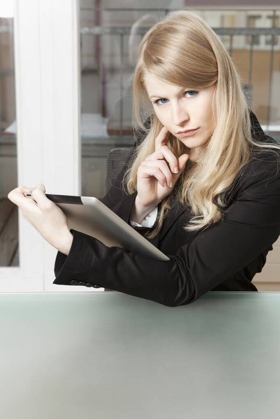 скептический взгляд на деловую женщину с планшетным ПК
 - Фото, изображение