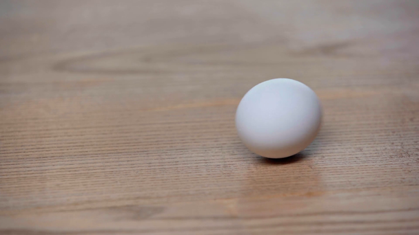cropped view of man spinning egg on table - Footage, Video