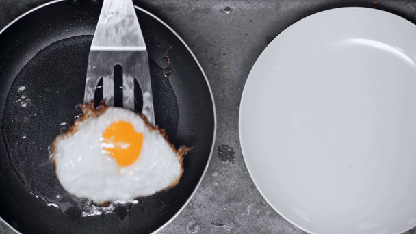 fried egg on frying pan near plate - Video, Çekim