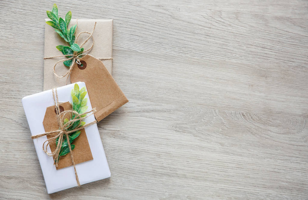Eko tarzı hediye paketi. Sırıtma dalı ve gülle süslenmiş hediye kutularıyla beste. Metin için yer - Fotoğraf, Görsel
