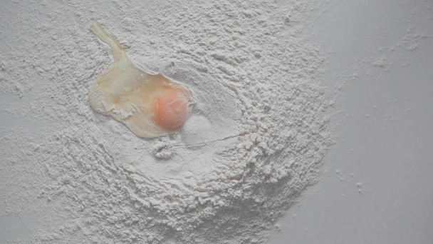 Movimento lento do ovo caindo na superfície com farinha
 - Filmagem, Vídeo