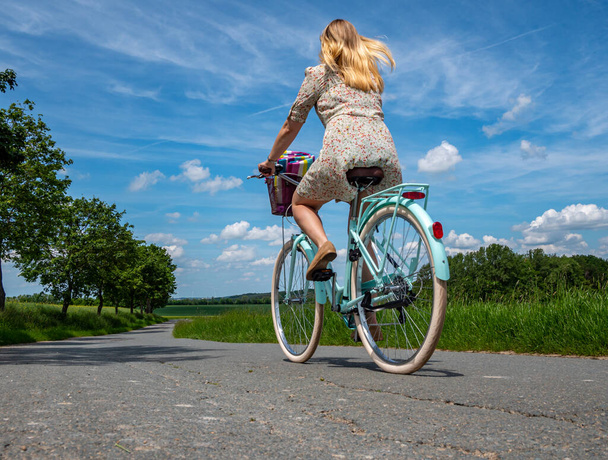 Por protección del clima joven mujer monta su bicicleta
  - Foto, imagen